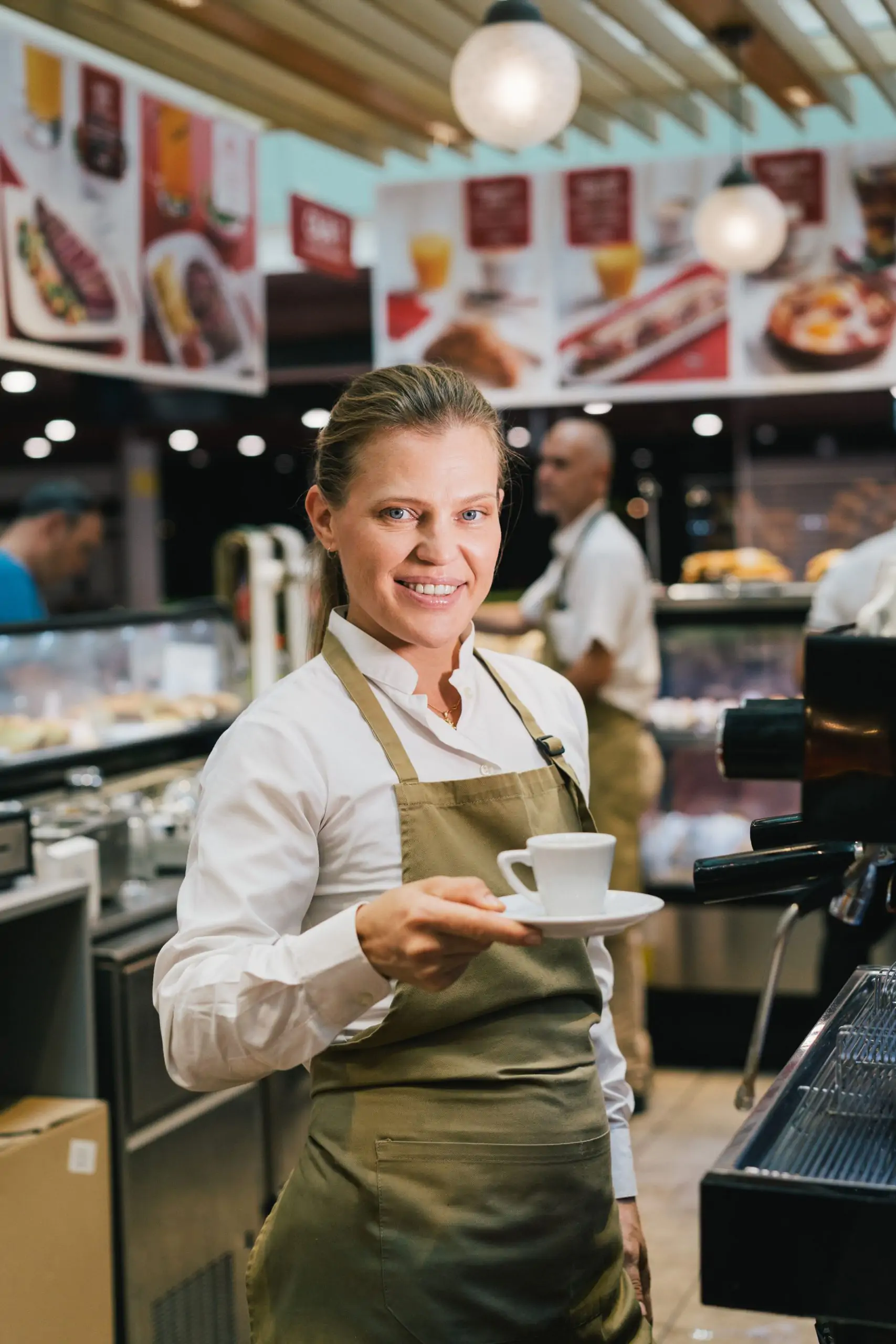 Barista serving a cup of coffee inside a café.